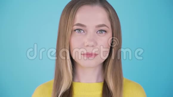 特写肖像蓝色背景下冷静的女孩孤立的背景4K视频的预览图