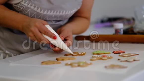 圣诞饼干的装饰过程靠近女人在节日的前夕带着悲伤的微笑装饰自制姜饼的男人视频的预览图