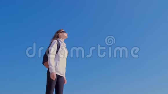 女旅行者带着背包享受大自然的蓝天背景度假视频的预览图