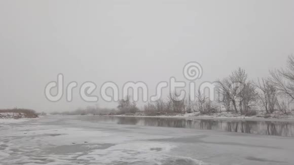 阴天雾天开放水的冰冻冬季河流视频的预览图