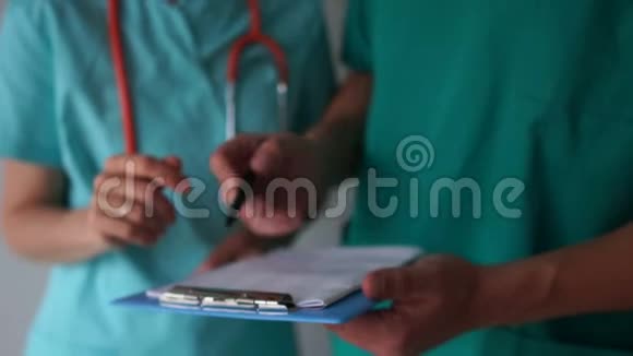 医生在助手手中的医疗文件上签字整理医生和文件视频的预览图
