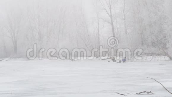 雾中的冬河冰上钓鱼的渔民视频的预览图