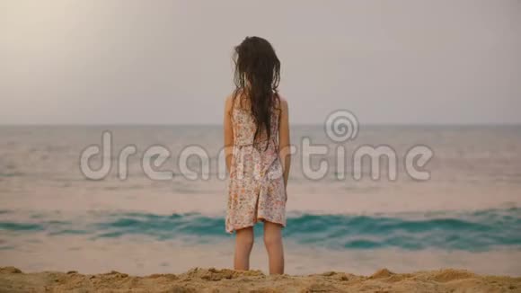 美丽的后景拍摄小女孩68岁在斯里兰卡热带异国情调的海洋海滩观看巨浪视频的预览图