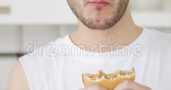 年轻人在家吃汉堡嘴和手都有食物特写视频的预览图