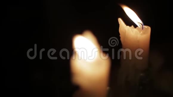 在黑暗的房间里燃烧蜡烛两支近距离观看的蜡烛在黑暗的房间里燃烧闪烁着耀眼的光芒视频的预览图