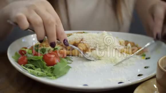 漂亮的女人正在吃火腿奶酪青菜和西红柿的煎饼视频的预览图