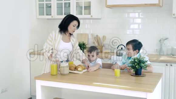 厨房里的幸福家庭妈妈为她的儿子做早餐视频的预览图