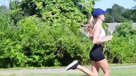 年轻女子正在慢跑锻炼心脏锻炼漂亮的运动女人在公园里跑步视频的预览图