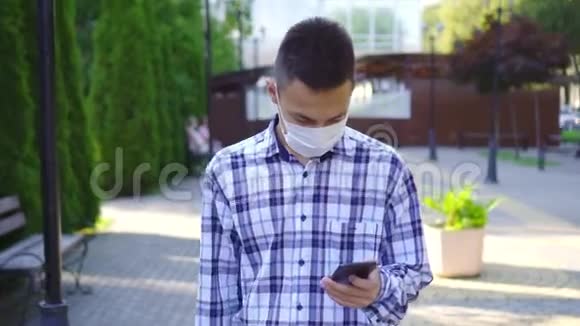 年轻的亚洲男人脸上带着医疗面具咳嗽他用智能手机视频的预览图