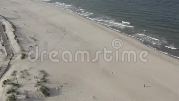 海边的沙滩上有汽车和游客的足迹视频的预览图