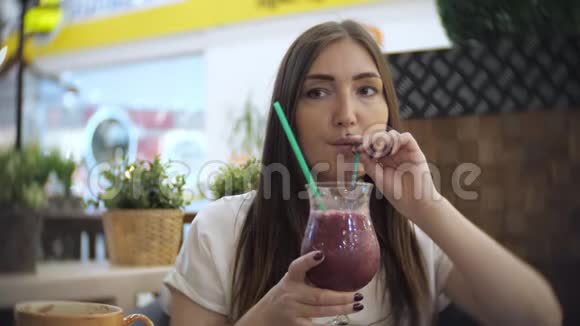 小女孩在咖啡馆喝冷饮鸡尾酒视频的预览图