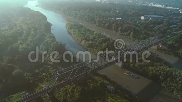 4K空中镜头无人机在河上的铁路桥下飞行视频的预览图