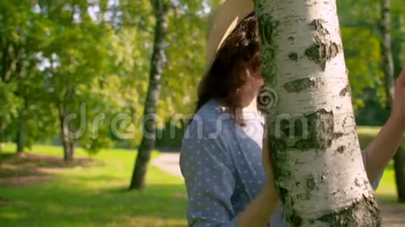 站在桦树旁边的年轻漂亮的女人视频的预览图