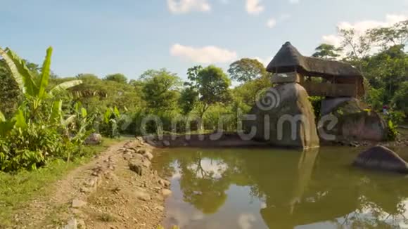 一个池塘边上的大型圣石上的土著建筑视频的预览图