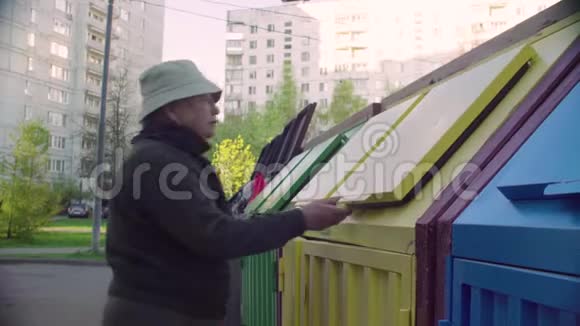 一位老妇人把垃圾放在一个单独的垃圾箱里视频的预览图