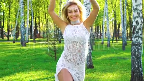 穿着性感服装在桦树林跳舞的微笑的女人镜头闪耀视频的预览图