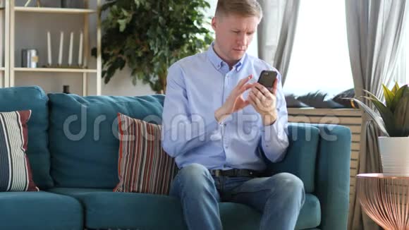 中年男子在使用智能手机时为成功而兴奋视频的预览图