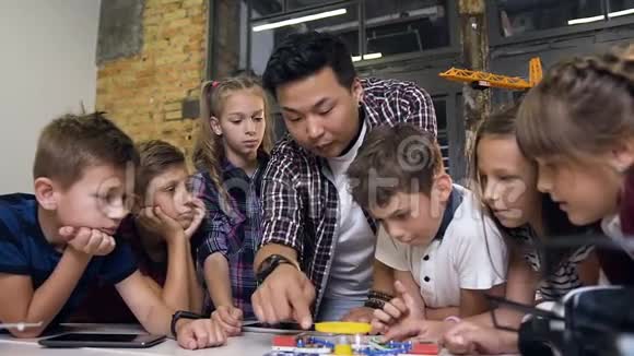 有创造力的孩子与老师一起启动电子构造器与风扇和转动手电筒有创意的学生视频的预览图