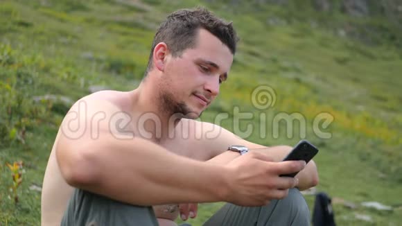 快乐的人坐着看着他的手机在格鲁吉亚山区的斯洛文尼亚视频的预览图
