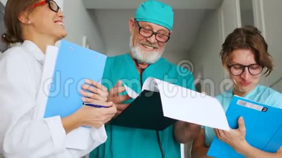 门诊医务人员上班同事医生笑医疗幽默三名穿着制服的医生视频的预览图