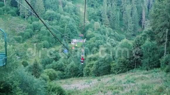 喀尔巴阡山滑雪椅上穿过绿色松林的人们夏天钢丝绳在山上拖曳假期视频的预览图