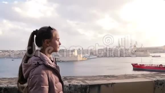 晚上一个年轻的女孩带着船走在码头附近美丽的风景成功自信的少年旅游视频的预览图