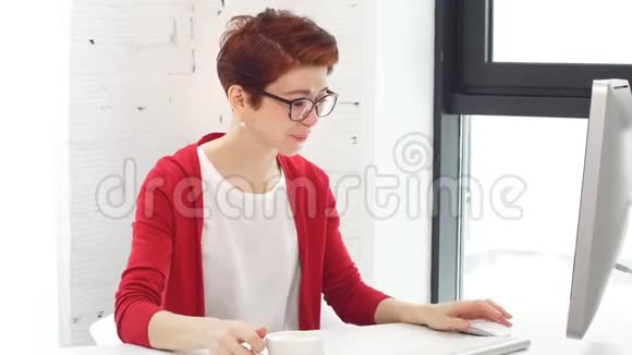 年轻的女商人在现代办公室的桌子上拿着咖啡杯视频的预览图