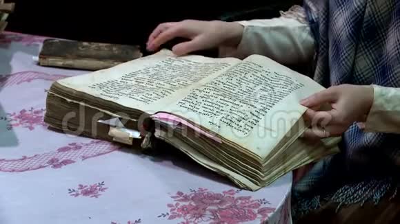 一个女人翻过一本旧书的书页视频的预览图