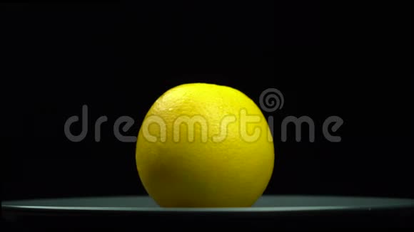 一个黄色的橙色在黑色背景的盘子上旋转视频的预览图