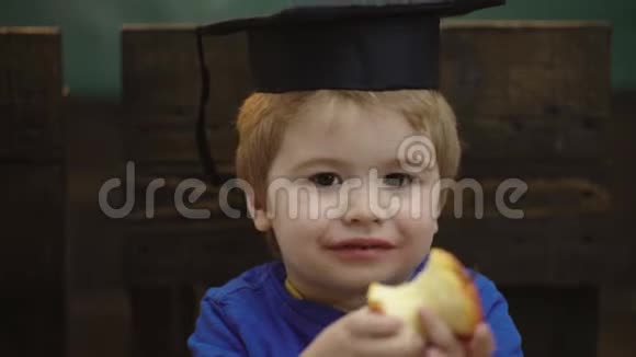 带着毕业帽和苹果的男孩学习观念穿制服的学童老师和学生回到学校视频的预览图