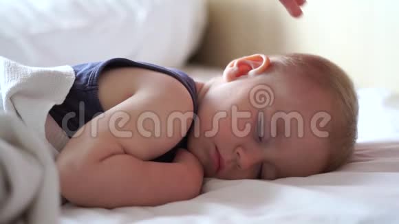 妈妈拍着婴儿的头而他却睡在床上动作很慢视频的预览图