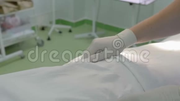 外科医生戴着白色防护橡胶手套在医院手术室的桌子上触诊病人视频的预览图