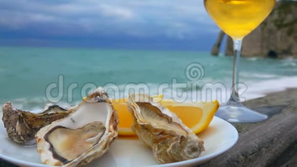 盛满新鲜牡蛎的盘子和一杯白酒视频的预览图