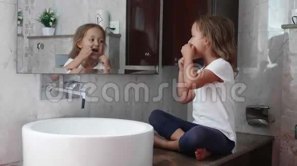 小可爱的女孩在镜子前用牙线刷牙视频的预览图