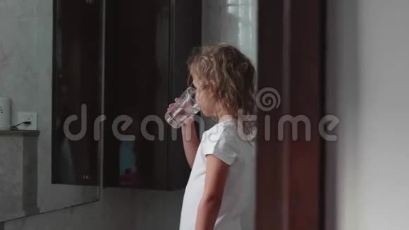 小卷发女孩在浴室里用水冲洗她的嘴侧视视频的预览图