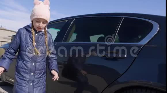 穿着冬装的少女正在汽车旁边跳舞视频的预览图