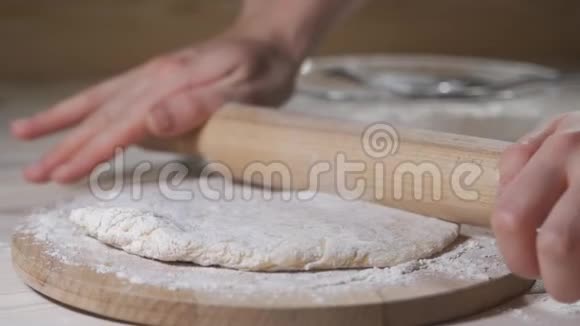 用男人的手在糕点厨房里做披萨或馅饼面团视频的预览图