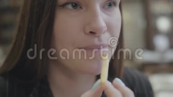 特写肖像年轻漂亮的女人坐在昂贵的餐厅吃鸡块与可口可乐视频的预览图