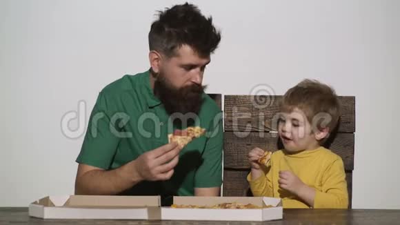 男孩和男人在白色背景下孤立地吃披萨美味的披萨小男孩在吃披萨饥饿的孩子和视频的预览图