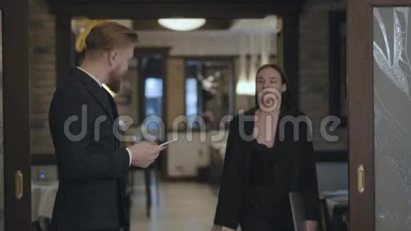 肖像男女商业伙伴在餐厅见面人们握手穿着优雅西装的女士视频的预览图
