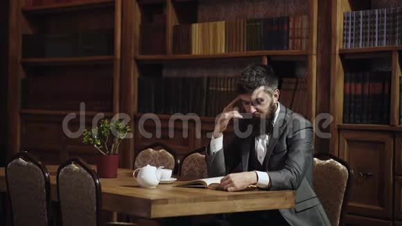 书柜中古式木桌上的人在图书馆读书的画像聪明的男人视频的预览图