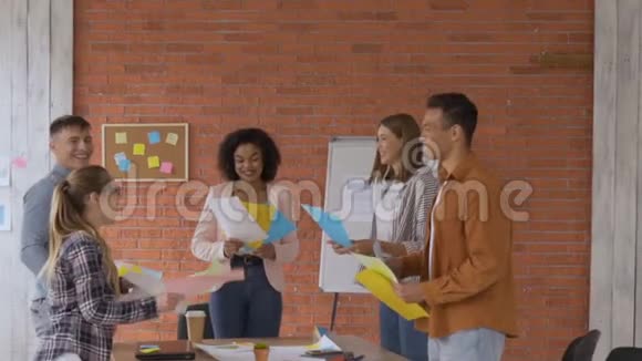 一组5人混合赛一队学生在一个现代化的办公室的背景上砖墙年轻人视频的预览图