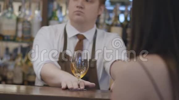 专业的年轻留胡子的男人和不可辨认的黑发女人坐在酒吧柜台混合酒保视频的预览图