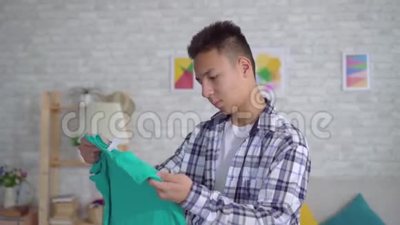年轻人把衣服烫在熨衣板上视频的预览图
