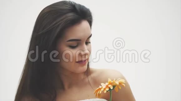 美丽的裸妆女人带花一个女孩的美丽肖像从一朵粉彩的花干净的脸小心视频的预览图