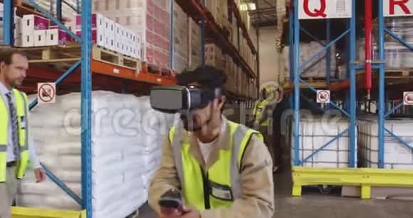 男性仓库工人使用VR耳机和控制器在装载舱4k视频的预览图