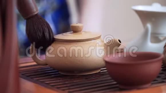 用特制的茶刷把水壶从热滴中擦干净视频的预览图