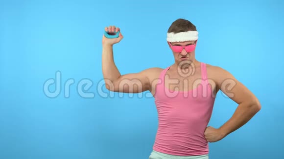 顽皮的帅哥手里拿着一个手动扩张器光明健身运动时尚配件视频的预览图