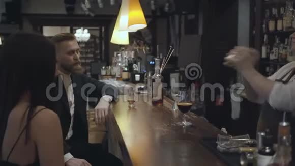 经验丰富的服务员站在一家昂贵的餐厅或酒吧的酒吧后面用摇床做鸡尾酒视频的预览图