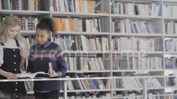 欧洲和非洲裔美国妇女正在图书馆看书视频的预览图
